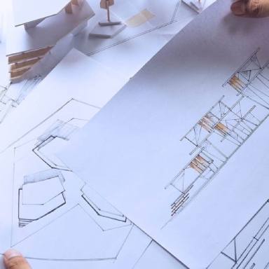 Architectural concept design drawings spread over a table